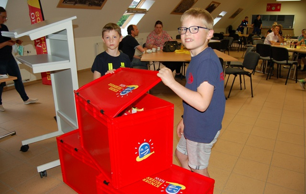 Jonas Weiß (vorne) und Marlon „inspizieren“ eine große Spielkiste, die der Verband der Feuerwehren in NRW zur Verfügung gestellt hat. 